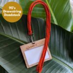 Repurposed orange drawstring rental lanyard for eco-friendly meetings and events with plastic-free name tag holder