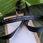Inside "Please return this lanyard" print on black, recycled rental event lanyard with paper badge holder for zero-waste events