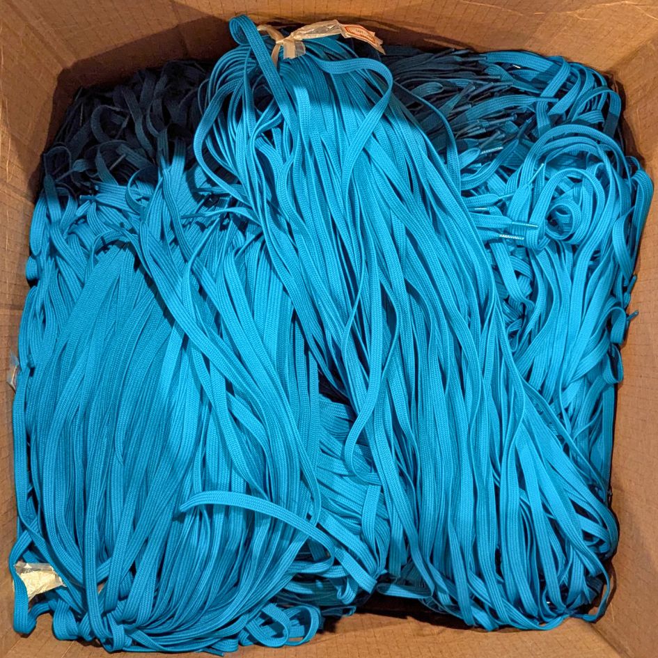 Box of blue fashion overrun strings for recycled repurposed sustainable conference and event lanyards