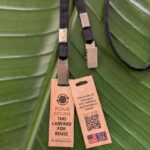 Close up of wood return hang tag for black lanyard with double bulldog clips made from salvaged materials in USA