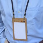 Person wearing kraft paper conference 4.25 X 6 badge holder and salvaged double bulldog hook lanyards made in USA