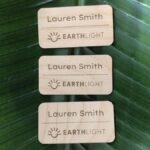 View of three eco-friendly, plastic free alderwood name tags personalized and made in USA