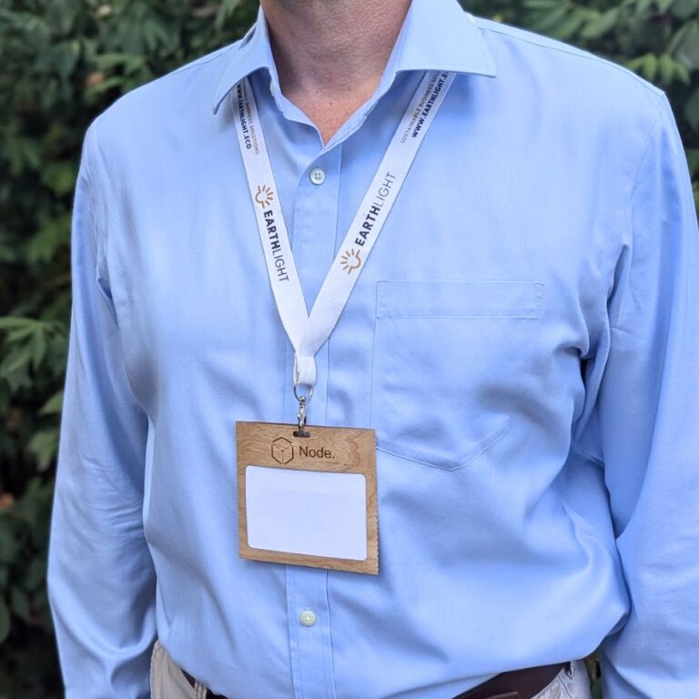 Person wearing laser engraved conference badge made in USA from plastic-free FSC Certified wood and organic cotton eco-friendly lanyard