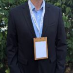 Person in suit jacket wearing plastic-free, wood Cherry badge holders for 4.25" x 6" inserts