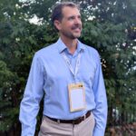 Person wearing plastic-free, wood overlay 4.25" x 6" name badge holder for sustainable event